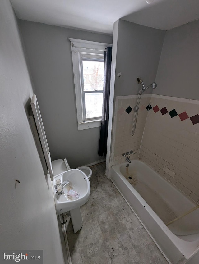 bathroom featuring toilet and tiled shower / bath