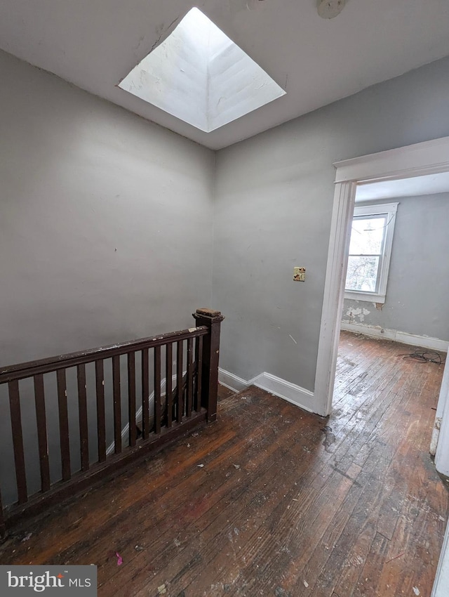 stairs with a skylight and hardwood / wood-style floors