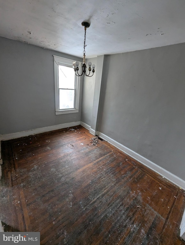 unfurnished dining area featuring dark hardwood / wood-style flooring and an inviting chandelier