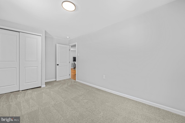 unfurnished bedroom with a closet and light carpet