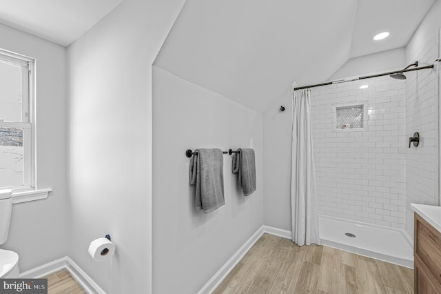 bathroom featuring toilet, vanity, vaulted ceiling, and a shower with shower curtain