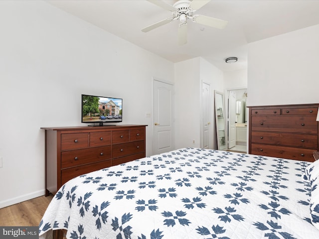 bedroom with ceiling fan, connected bathroom, and hardwood / wood-style floors