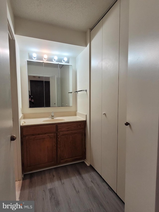 bathroom featuring vanity, hardwood / wood-style floors, and a textured ceiling