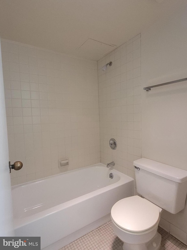 bathroom with tiled shower / bath, tile patterned floors, and toilet