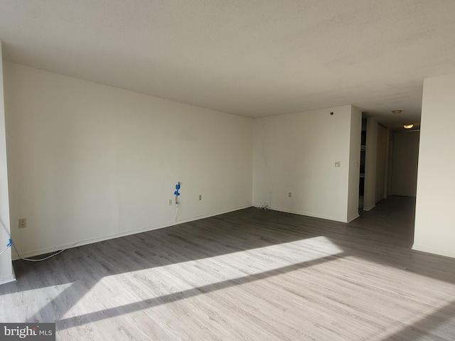 unfurnished room with hardwood / wood-style flooring