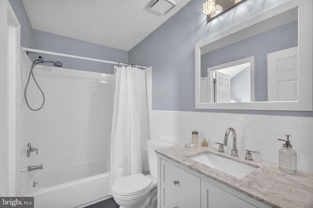 full bathroom with backsplash, toilet, vanity, and shower / tub combo with curtain