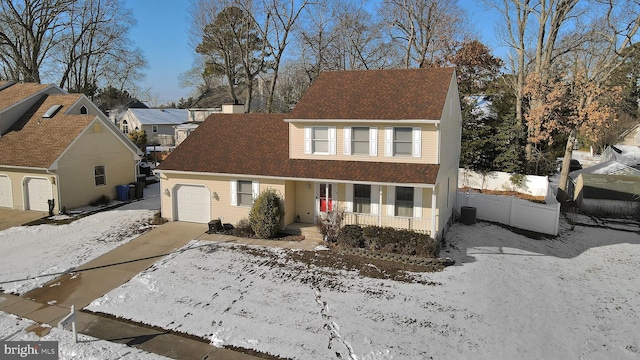 view of front of home with covered porch, central air condition unit, and a garage