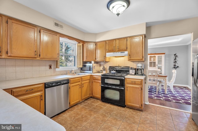 kitchen with sink, decorative backsplash, light tile patterned floors, and stainless steel appliances