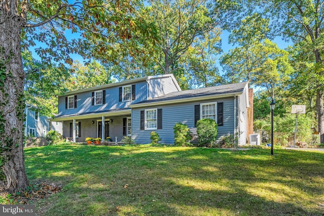 view of front of home with central AC and a front yard