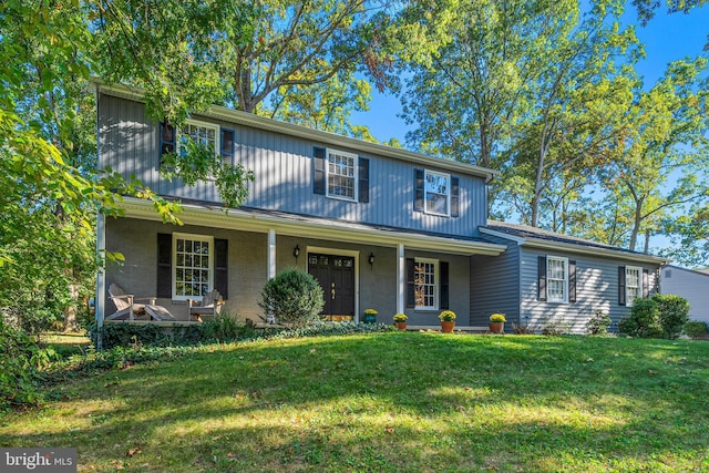 view of front of home with a front yard and covered porch