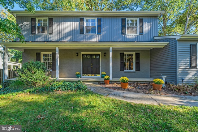 front of property with a porch and a front lawn