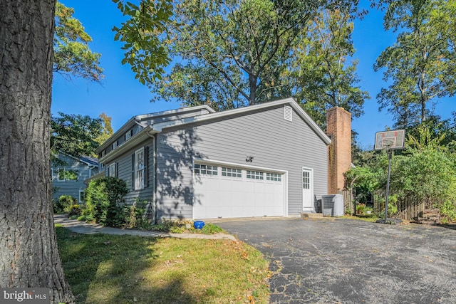 view of front facade featuring a garage and central AC