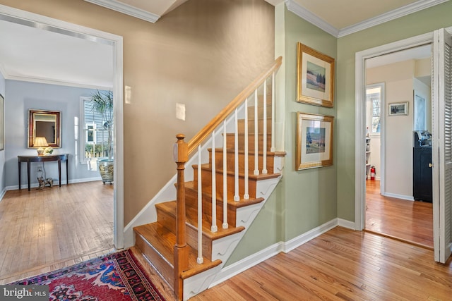 stairs with hardwood / wood-style flooring and ornamental molding