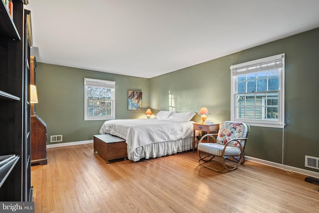 bedroom with light hardwood / wood-style floors and multiple windows