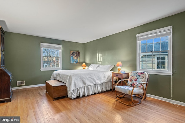 bedroom with multiple windows and light hardwood / wood-style flooring