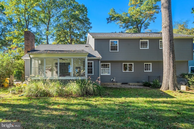 back of property featuring a sunroom and a lawn