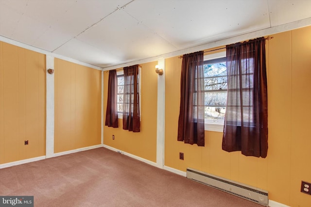 spare room with baseboard heating, plenty of natural light, baseboards, and carpet