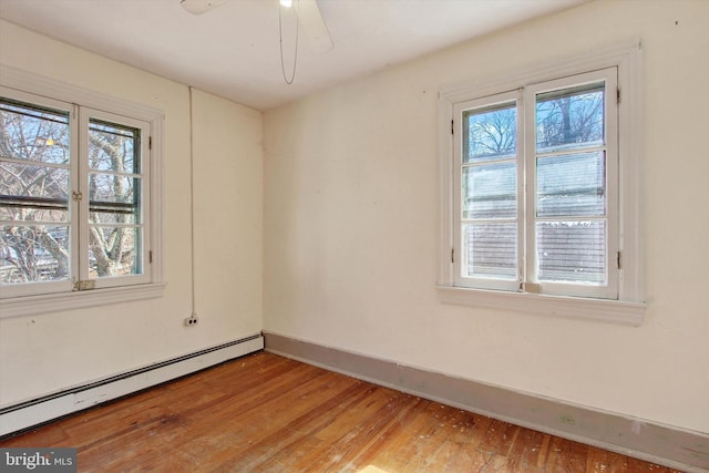 unfurnished room with a healthy amount of sunlight, baseboards, light wood-style floors, and a baseboard radiator