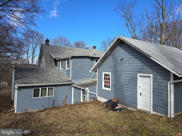 back of property featuring roof with shingles