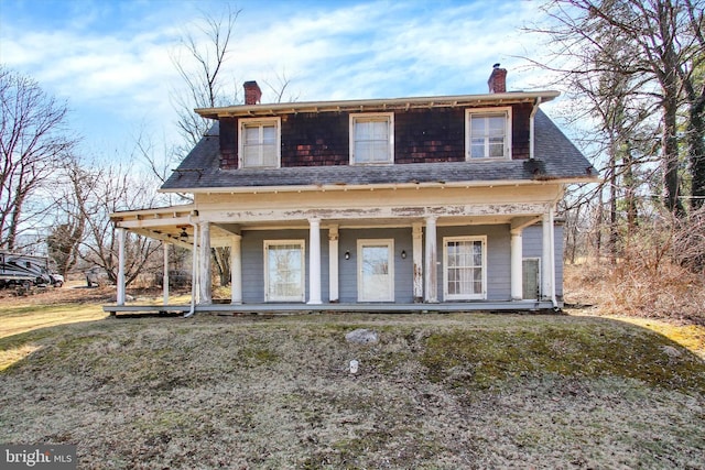 view of front facade featuring covered porch and a chimney