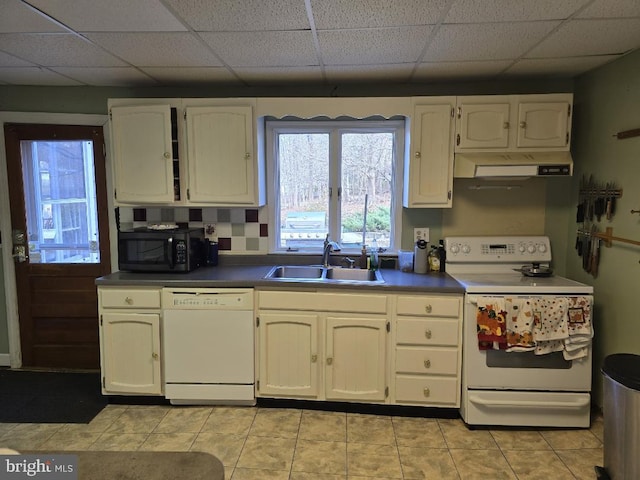 kitchen featuring a drop ceiling, sink, white appliances, and light tile patterned floors