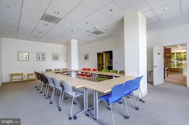 dining area with light carpet and a drop ceiling