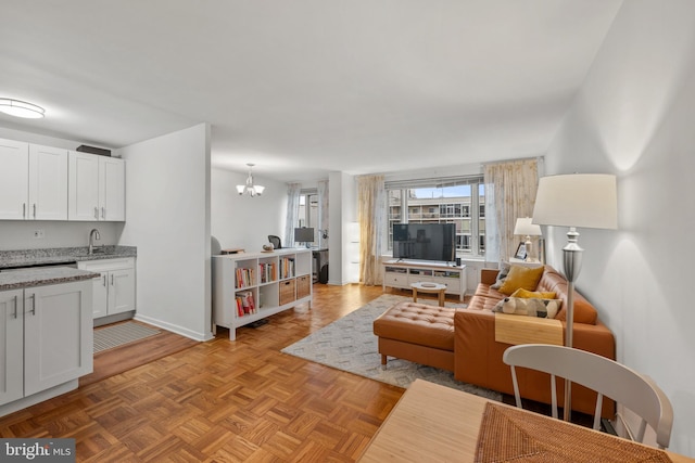 living room featuring sink, a chandelier, and light parquet floors