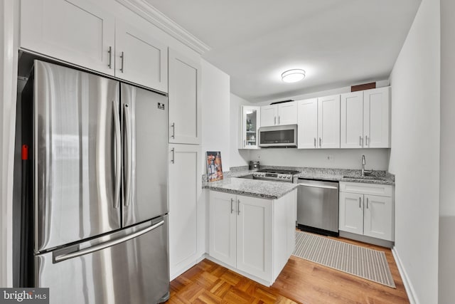 kitchen featuring light stone countertops, appliances with stainless steel finishes, sink, and white cabinets