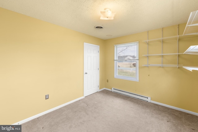 empty room featuring a textured ceiling, a baseboard heating unit, carpet flooring, visible vents, and baseboards