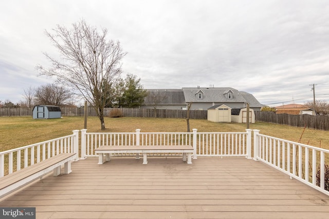 deck featuring a storage shed, a lawn, an outdoor structure, and a fenced backyard