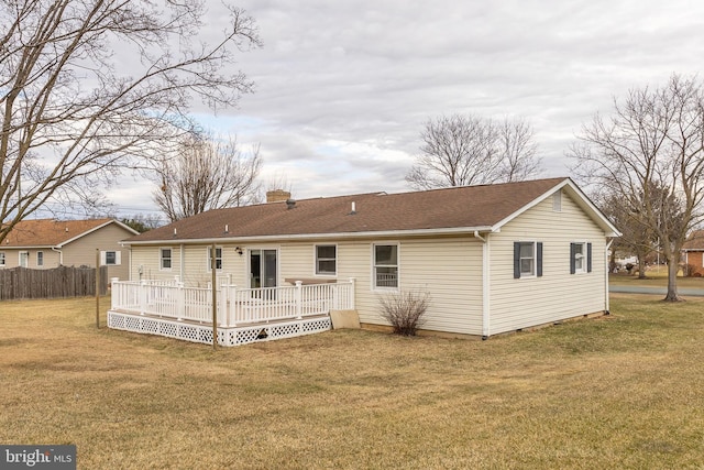 back of property featuring a deck, a shingled roof, fence, a yard, and a chimney