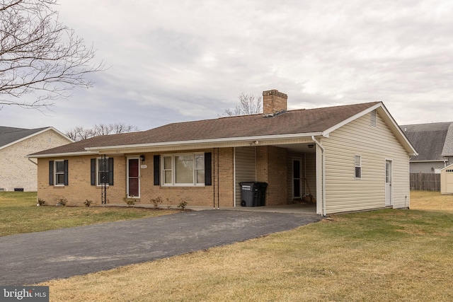 ranch-style home with a chimney, aphalt driveway, a front yard, a carport, and brick siding