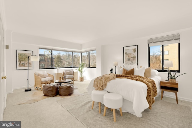 bedroom with light colored carpet and multiple windows