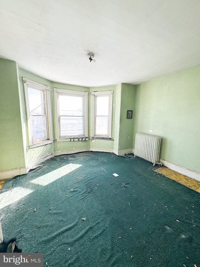 carpeted empty room featuring radiator