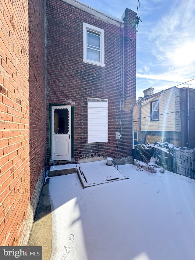 view of snow covered rear of property