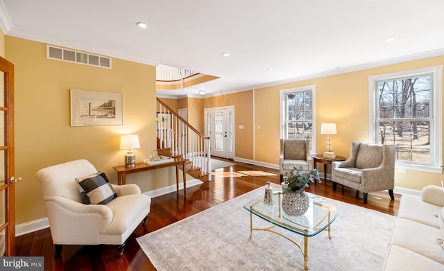 living room with visible vents, baseboards, hardwood / wood-style flooring, stairway, and crown molding