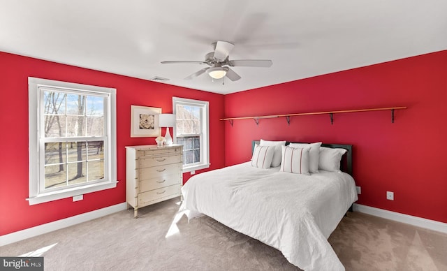 carpeted bedroom featuring a ceiling fan, visible vents, and baseboards