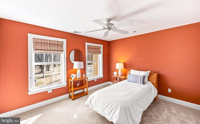 carpeted bedroom featuring a ceiling fan, visible vents, and baseboards