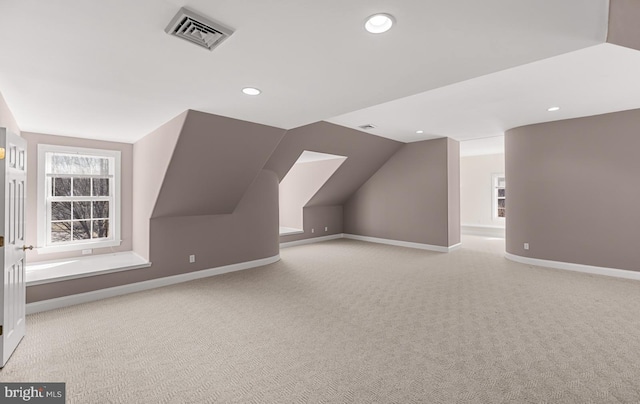 bonus room with baseboards, visible vents, vaulted ceiling, and carpet flooring