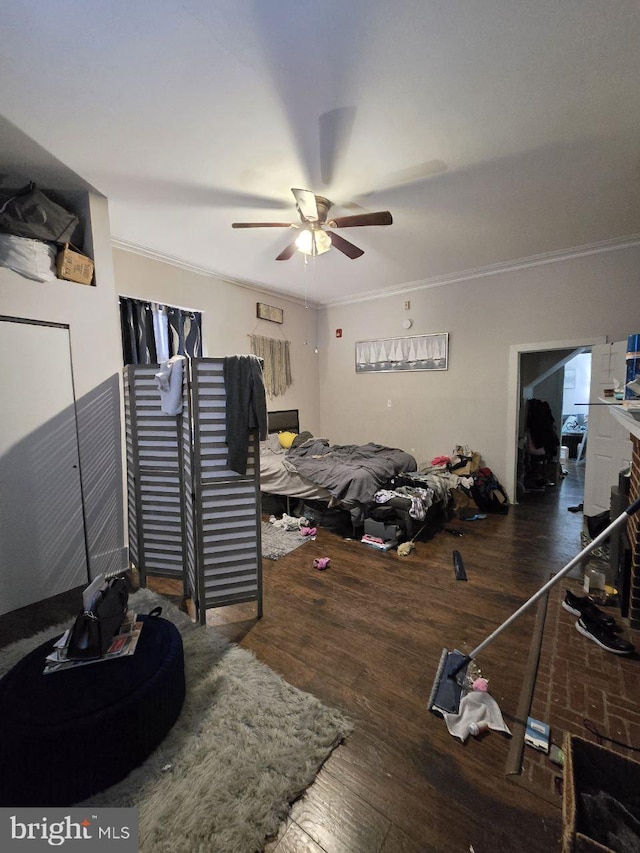 bedroom featuring ornamental molding, dark wood-type flooring, and ceiling fan