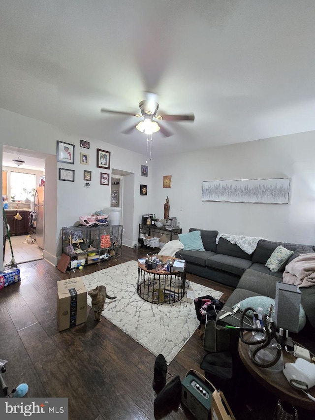 living room with dark wood-type flooring and ceiling fan