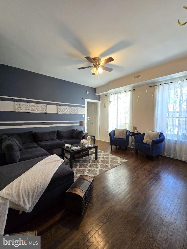 living room featuring ceiling fan and dark hardwood / wood-style floors