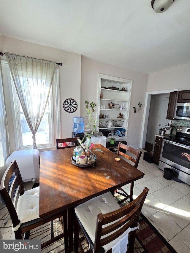 dining room with built in shelves and light tile patterned floors