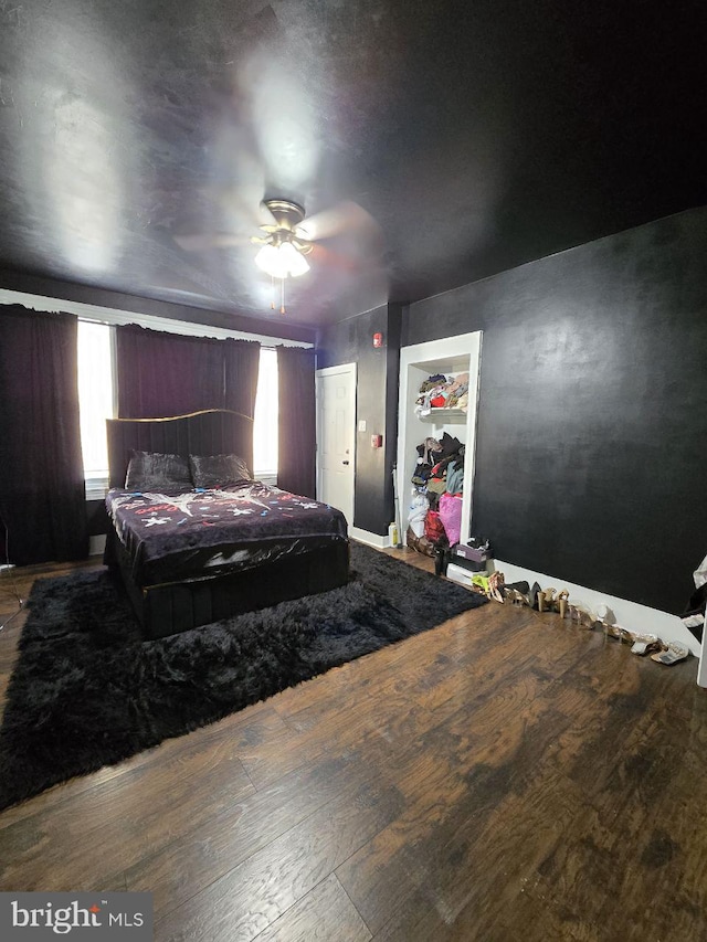 bedroom featuring multiple windows, hardwood / wood-style floors, and ceiling fan