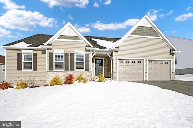 view of front of property featuring driveway, stone siding, and an attached garage