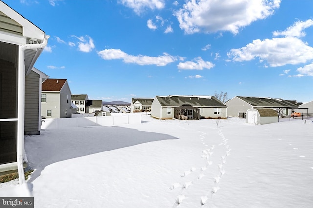 yard covered in snow with a storage unit