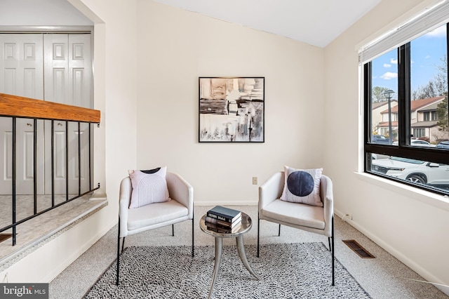 sitting room featuring vaulted ceiling and carpet flooring