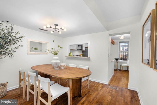 dining area featuring hardwood / wood-style flooring and a notable chandelier