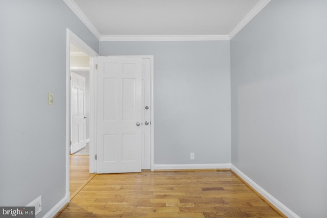 empty room featuring ornamental molding and light wood-type flooring