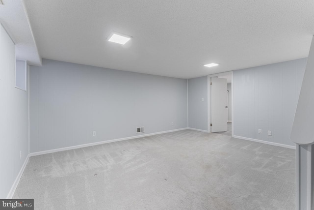 basement with light colored carpet and a textured ceiling